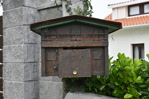 Charming Mailbox: Wooden House-Shaped Letterbox Adorning Exterior Home - A Quaint Touch of Rural Charm