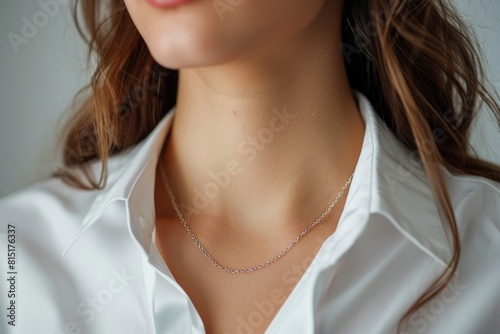 A woman wearing a white shirt and a silver necklace