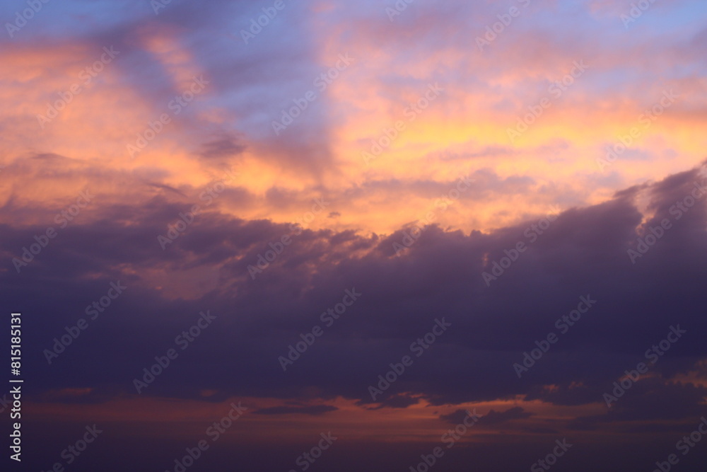 a sunset sky with clouds and a purple sky with a few clouds.