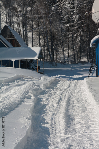 Snowy road with a blue building in the freezing winter