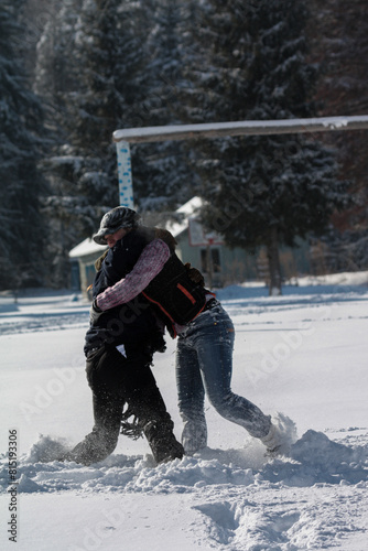Man braves freezing snow to carry another in winter sports gear for a fun event