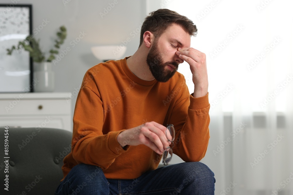 Overwhelmed man with glasses suffering at home Overwhelmed man with glasses suffering at home