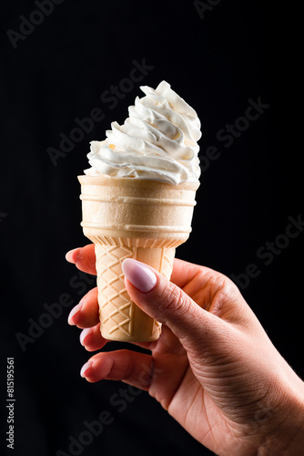 Woman's hand holding wafer cone with ice cream
