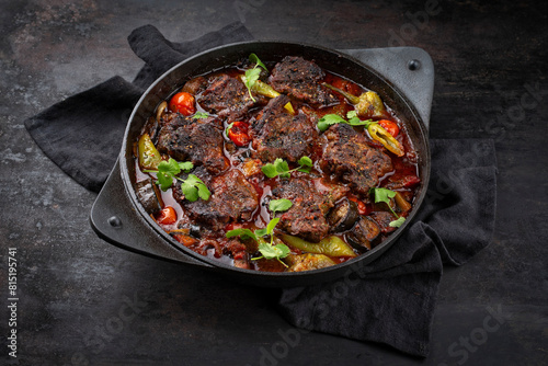 Traditional Greek braised lamb stew with vegetables and olives in a hearty meat sauce with red wine served as a close-up in a designer casserole with text space © HLPhoto