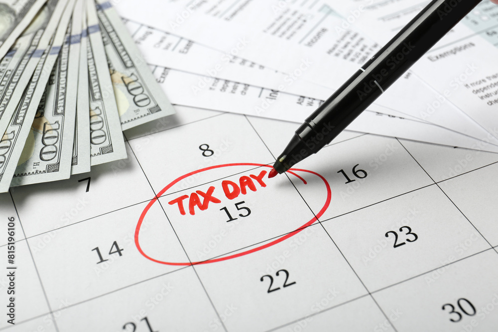 Marking tax day in calendar, felt pen, documents and money, closeup Marking tax day in calendar, felt pen, documents and money, closeup