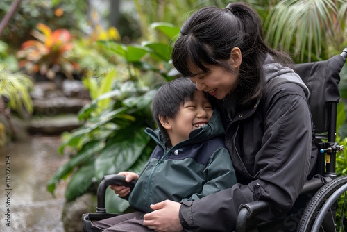  Joyful Asian Mother and Son Laughing in Wheelchairs in Lush Garden © MarGa