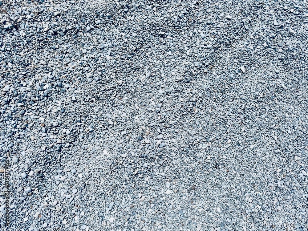A detailed view of a gravel pile composed of crushed rock, showcasing its rugged texture and varying shades of gray, evoking an industrial and raw aesthetic. A detailed view of a gravel pile composed of crushed rock, showcasing its rugged texture and varying shades of gray, evoking an industrial and raw aesthetic.