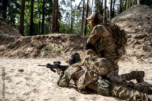 Ukrainian soldiers shoot from a rifle on the sand