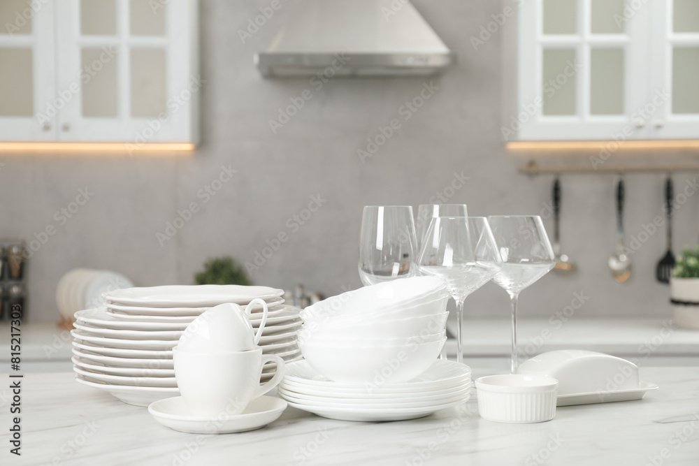 Clean plates, bowls, cups and glasses on white marble table in kitchen Clean plates, bowls, cups and glasses on white marble table in kitchen