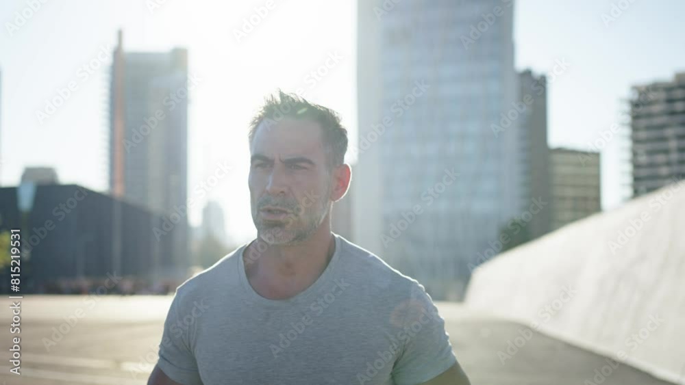 Middle-aged Caucasian man running alone in an urban area. Disciplined male workout burning calories for a healthy body. Sports and training lifestyle. Effort, sacrifice, discipline. Slow motion