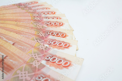 Red Russian paper banknotes of 5000 rubles on white light background. Cash money of Russia. Ruble. Concept of shopping, currency exchange, tax, travel, devaluation, financial crisis, debt, loan. Bill