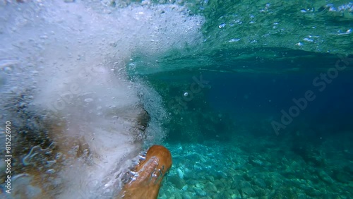 SLOW MOTION: Adventurous dog leaping into crystal clear turquoise sea from a rocky shore. Cute brown doggo enjoys on summer holidays and is always ready to dive into inviting waters of Adriatic Sea.