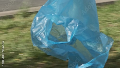 A blue empty plastic shopping bag flies in the wind in the park, showcasing efforts to protect the environment from plastic pollution. for supermarket polythene pack