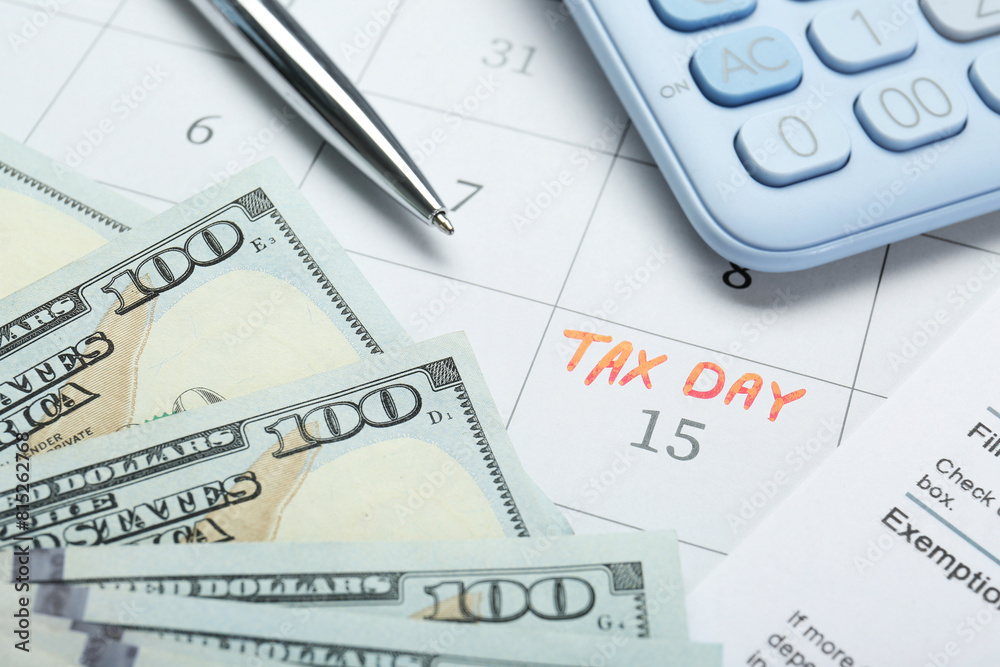 Tax day. Document, dollar banknotes, calculator and pen on calendar with date reminder Tax day. Document, dollar banknotes, calculator and pen on calendar with date reminder