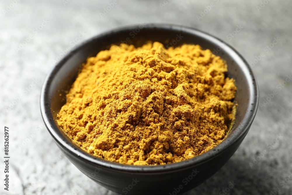 Dry curry powder in bowl on dark table, closeup Dry curry powder in bowl on dark table, closeup