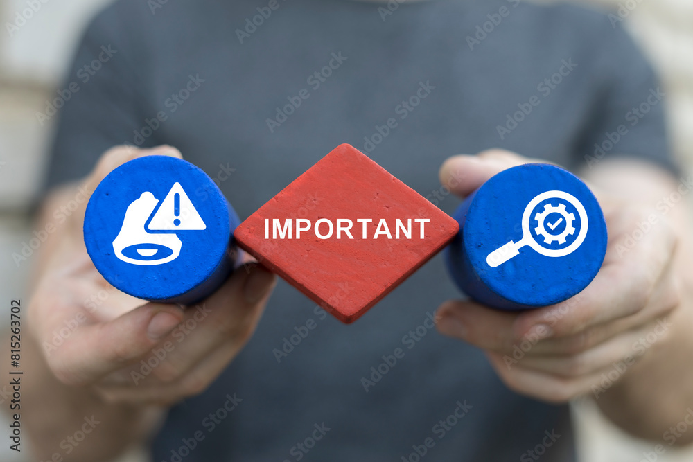 Man holding styrofoam blocks with icons sees word: IMPORTANT. Important announcement, attention or warning information, breaking news or urgent message communication, alert and beware concept. Man holding styrofoam blocks with icons sees word: IMPORTANT. Important announcement, attention or warning information, breaking news or urgent message communication, alert and beware concept.