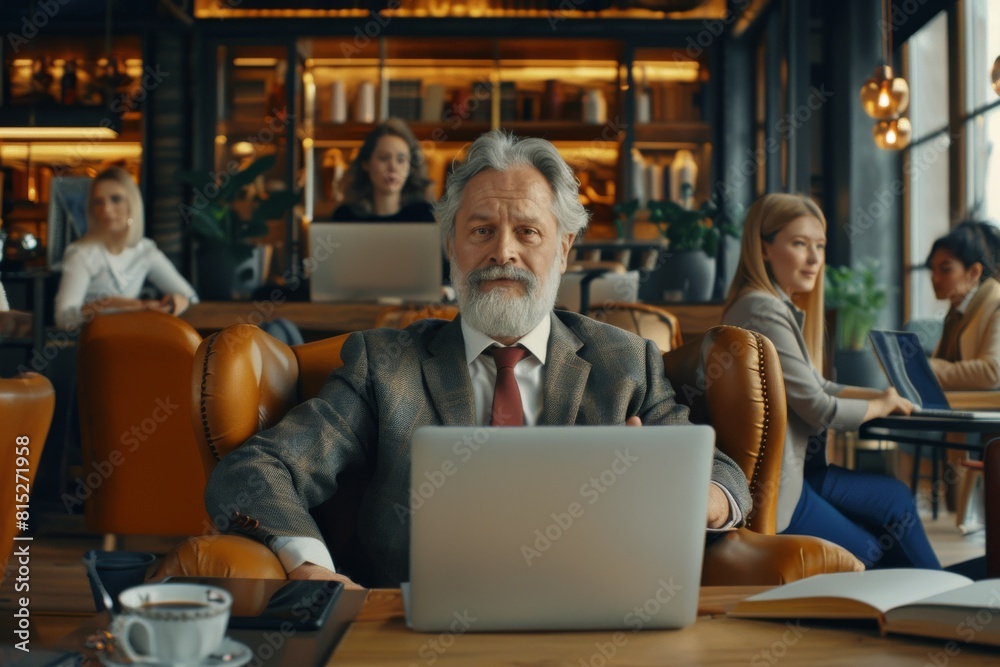 Portrait of a senior businessman using a laptop in a coffee shop