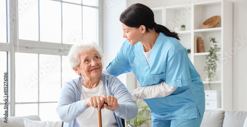Senior woman in wheelchair with stick and nurse at home