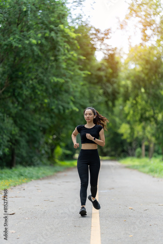 Healthy young female runner stretches her legs before running in the park. Woman exercising for health, jogging outdoors, concept of people and lifestyle, health and well-being. In parks and outdoors © MrAshi
