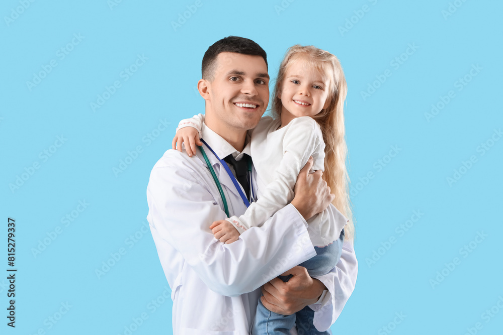 Male pediatrician and little girl on blue background