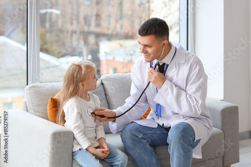 Male pediatrician examining...