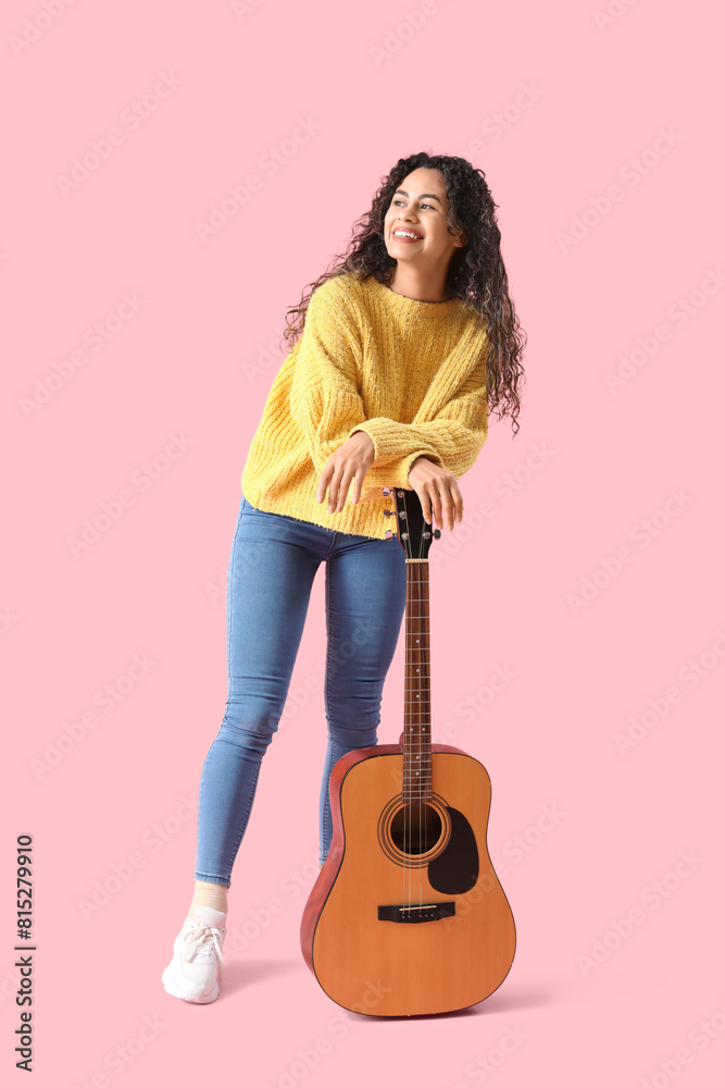 Young African-American woman with acoustic guitar on pink background Young African-American woman with acoustic guitar on pink background