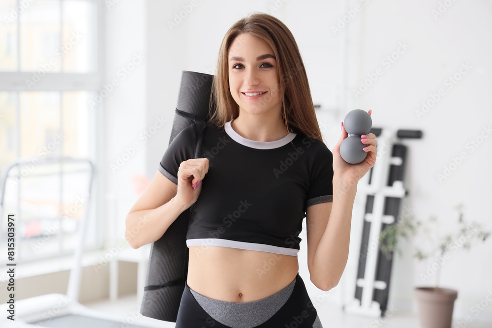 Sporty young woman with massage balls and mat at gym Sporty young woman with massage balls and mat at gym