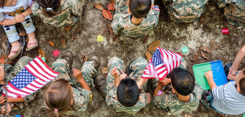 Kids in military uniforms with American flags during a Memorial Day picnic, overhead view. photo