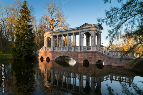 Marble bridge on the shore of a Large pond in the Catherine Park in Tsarskoye Selo on a sunny spring day, Pushkin, St. Petersburg, Russia