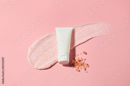 Photo for advertise exfoliating product which has himalayan pink salt as the main ingredient, a white tube without label flat lay on pastel pink background. Top view photo with mock up for advertising