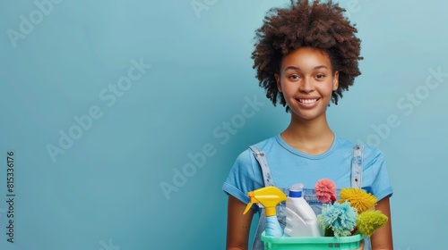 cleaning lady with a blue shirt holding a caddy with cleaning products on blue background copy space  photo