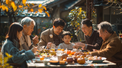 A happy multigenerational Asian family gathers around a festive table  enjoying a meal together in a cozy outdoor setting.