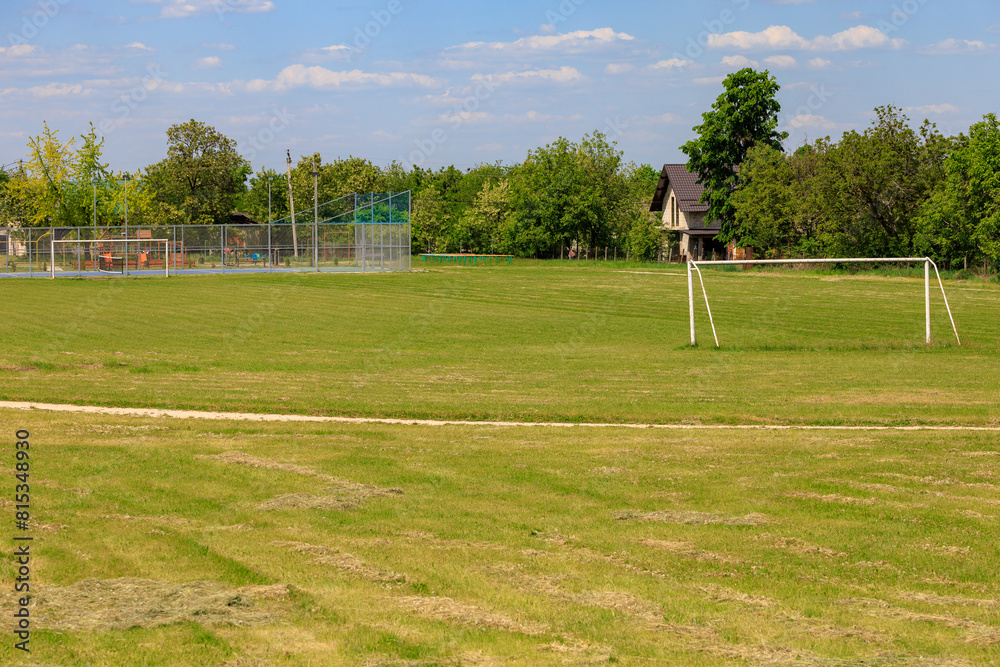Fototapeta premium A large field with a soccer field and a house in the background