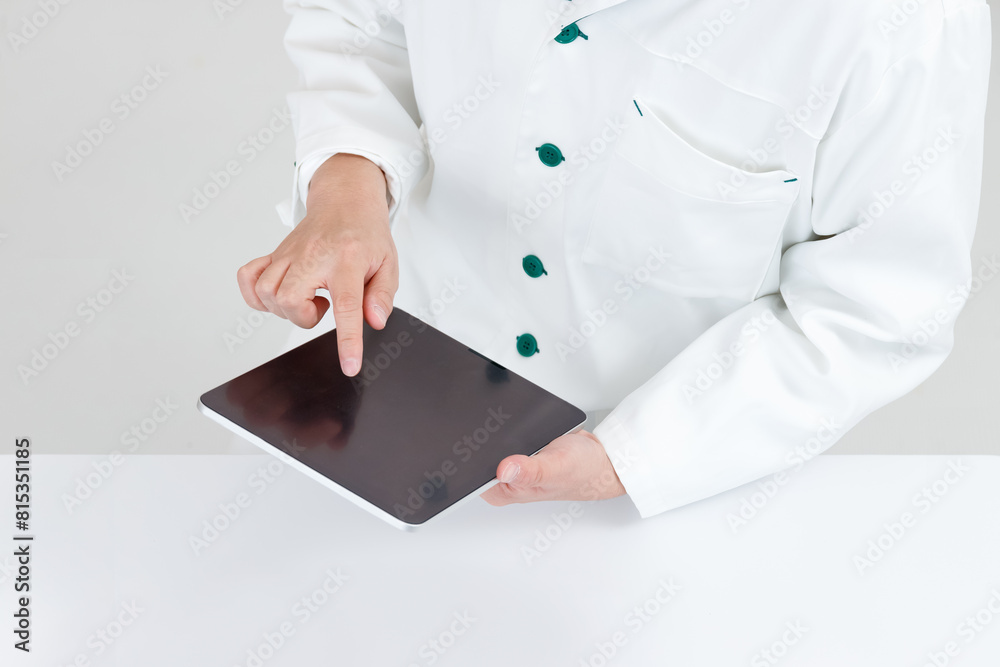 タブレットを操作する薬剤師または医師の手元。オンライン診療や遠隔医療イメージ タブレットを操作する薬剤師または医師の手元。オンライン診療や遠隔医療イメージ