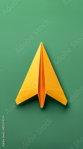 Little plane made of paper in origami style on a green background. Yellow origami plane in takeoff, new idea and leadership concept.