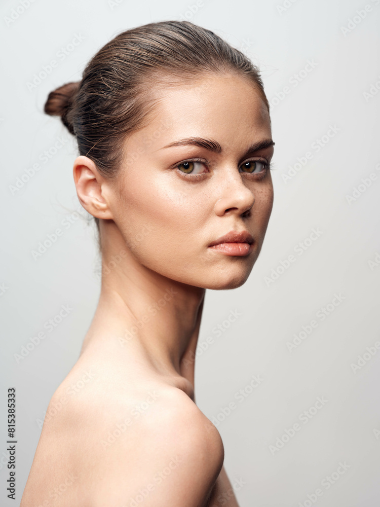 Beauty portrait of a young woman with flawless skin on white background, isolated on grey background, in studio setting Beauty portrait of a young woman with flawless skin on white background, isolated on grey background, in studio setting