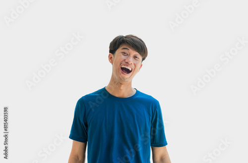 Young Asian man in blue t-shirt making funny face isolated on gray background