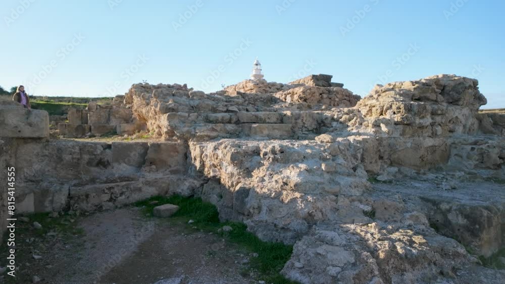 The ruins at the Archaeological Site of Nea Paphos, with a lighthouse in the background. The stone structures, emphasizing the site's historical and architectural value The ruins at the Archaeological Site of Nea Paphos, with a lighthouse in the background. The stone structures, emphasizing the site's historical and architectural value