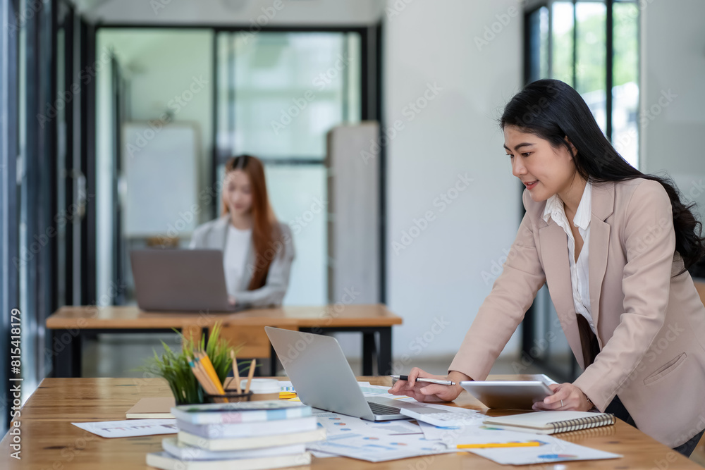 Asian business woman working In office using laptop and tablet, business concept Asian business woman working In office using laptop and tablet, business concept