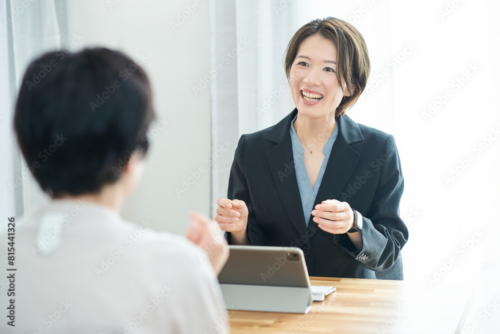 Fototapeta premium 私服の女性に説明するスーツ姿の女性