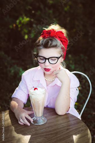 Young woman with milkshake outdoors in vintage style photo