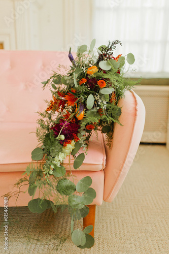 Vibrant Bridal Bouquet Cascades Down Pink Velvet Couch photo