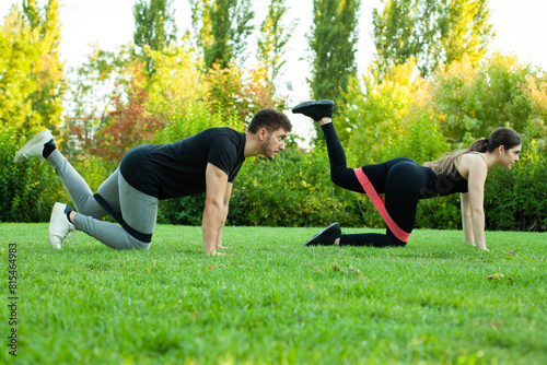 pareja de hombre y mujer haciendo deporte en el parque con bandas elásticas en las piernas. Deporte al aire libre. Estilo de vida saludable