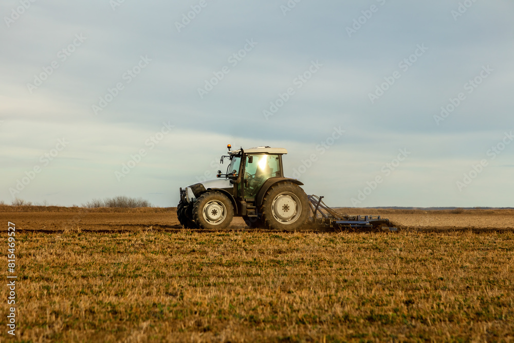 Landscape view of a farmer plowing fertile fields under a vast sky Landscape view of a farmer plowing fertile fields under a vast sky