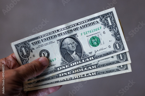 Fotografija Hand holding three one US Dollar banknotes