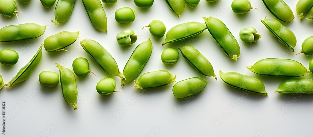 Copy space image of fresh uncooked peas arranged in a top view with a white background The close up reveals closed whole green pods neatly positioned on a flat surface