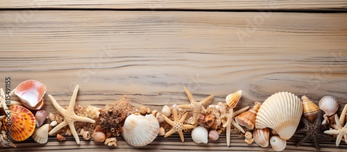 From an aerial view the image shows a vintage wooden texture background adorned with seashells accessories and plenty of copy space for a summer holiday travel theme