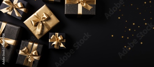 Flat lay of black Friday and holiday themed cardboard gift boxes placed on a black background creating a visually pleasing copy space image © HN Works