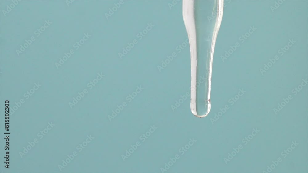 Macro video of dropper & beaker on plain background. Close up of scientific lab equipments on coloured background. Drops of transparent liquid falling from top.