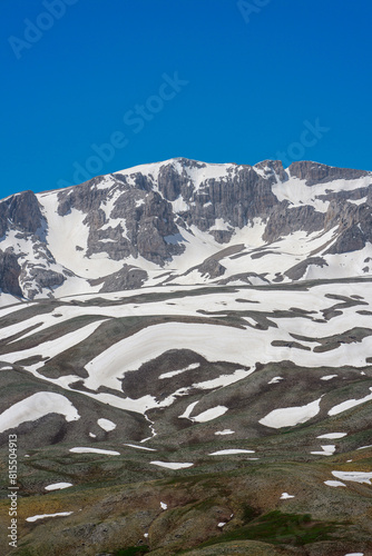 The lush green Sobucimen plateau in spring and the mountains with some melted snow behind. photo